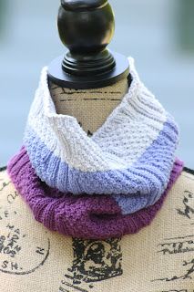 a close up of a mannequin wearing a purple and white knitted scarf