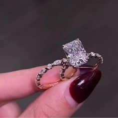 a person holding a diamond ring in their hand with the engagement band on top of it