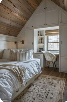 a white bed sitting under a window next to a wooden ceiling in a room filled with furniture