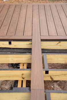 a close up of a wooden deck with metal bars on the bottom and one side