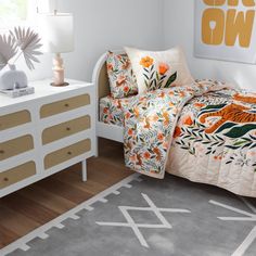 a bed room with a neatly made bed next to a white dresser and a painting on the wall