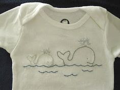 a white t - shirt with an embroidered whale on it