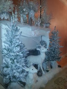 there is a fake fireplace with snow on the mantle and trees in front of it