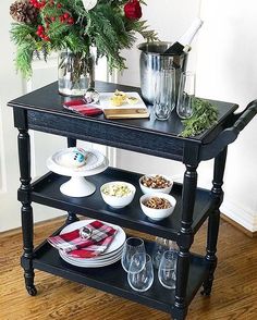 a table with plates, cups and glasses on it next to a potted plant