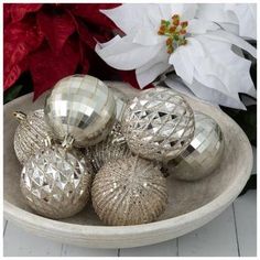 silver christmas ornaments in a bowl on a table