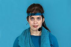 a woman wearing a headset and blue shirt is looking at the camera with a surprised look on her face