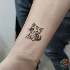 a small kitten tattoo on the wrist