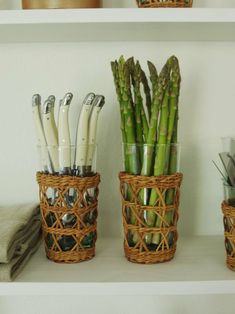 there are three baskets on the shelf with different kitchen utensils and knives in them