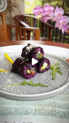 a plate with some food on top of it and purple flowers in the back ground