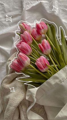 a bouquet of pink tulips sitting on top of a white cloth