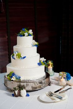 a wedding cake sitting on top of a table next to two forks and knifes