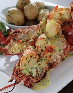 lobster and potatoes on a white plate with dipping sauce