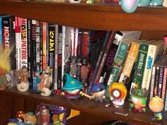 a book shelf filled with lots of books and figurines on top of it