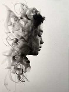 a black and white photo of a woman's face with hair blowing in the wind