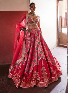 This exquisite banarasi lehenga, inspired by the elegance of jharokhas, is beautifully paired with a coral plunging V-neck sheeted blouse and a flowing organza dupatta. Delicately highlighted with cut mirrors and pearls, the ensemble radiates sophistication and charm. A stylish belt cinches the waist, enhancing the silhouette and completing this stunning look with a perfect blend of tradition and contemporary flair. Art Silk Lehenga With Sheer Dupatta, Raw Silk Sharara With Traditional Tilla Drape, Anarkali Chanderi Set With Meenakari, Anarkali Meenakari Set In Chanderi, Elegant Art Silk Lehenga With Tilla, Chanderi Lehenga For Wedding, Festive Art Silk Lehenga With Sheer Dupatta, Raw Silk Tilla Dupatta For Reception, Festive Silk Lehenga With Tilla Embroidery