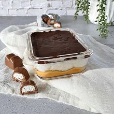 a chocolate covered dessert sitting on top of a white cloth next to two pieces of candy