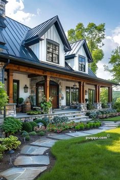 a large house with lots of windows and plants on the front lawn, along with stone steps leading up to it