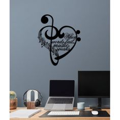 a computer desk with a laptop on it and a wall sticker in the shape of a heart