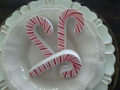 two candy canes sitting on top of a white plate