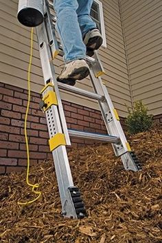 a man on a ladder up to the side of a house with his feet in the air