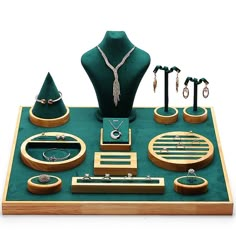 an assortment of jewelry is displayed on a green display case with gold trimmings