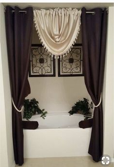 a bath tub sitting under a window next to a planter filled with potted plants