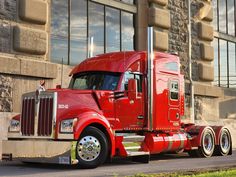 a red semi truck parked in front of a building