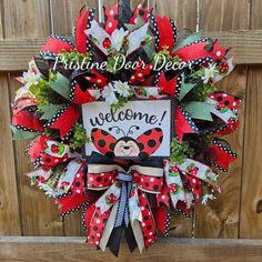 a red and black welcome wreath with ladybug on it