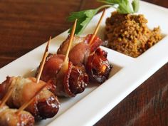 some food is on a white plate with toothpicks and garnishes