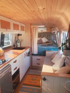 the interior of a small camper with wood paneling and white cabinets is shown