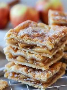 a stack of apple pies sitting on top of a cooling rack