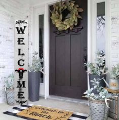 a welcome mat on the front porch with potted plants