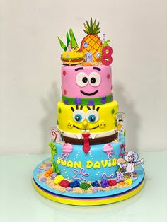 a three tiered cake decorated with spongebob faces and pineapples on top