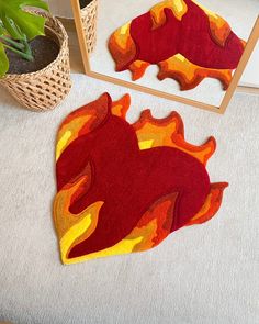 a red and yellow fire rug sitting on top of a floor next to a mirror