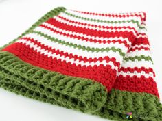 two red and green striped crocheted dishcloths sitting on top of each other