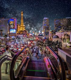 an escalator in las vegas at night with the eiffel tower in the background