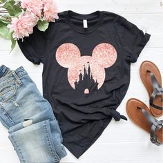 a black shirt with pink minnie mouse ears on it and some flowers next to it