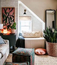 a living room filled with furniture and a plant in a vase next to a window