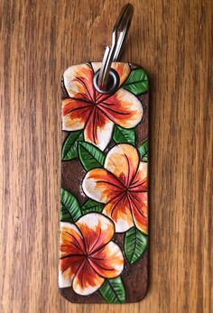 an orange and white flower is painted on a wooden surface with a pair of scissors