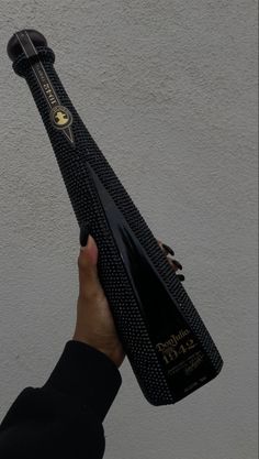 a person holding up a black and gold tie