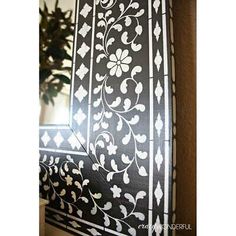 the window is decorated with black and white designs on it's side wall, along with a potted plant in the corner