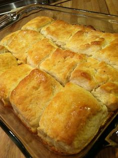 a glass baking dish filled with bread on top of a wooden table