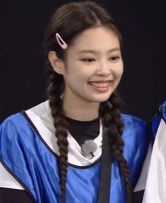 two girls in graduation gowns are smiling for the camera while one girl has braids on her head