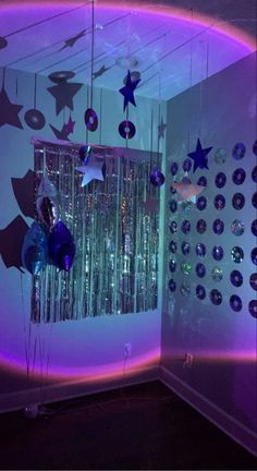 a room filled with purple and blue decorations on the wall next to a mirror ball chandelier