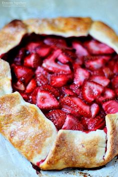 a pie with strawberries in it sitting on top of a table