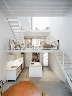 an open floor plan with stairs leading up to the upper level and kitchen on the far side