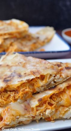 Two pieces of quesadilla stacked on a white plate.