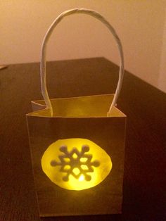 a paper bag with a glowing snowflake design on it sitting on a table