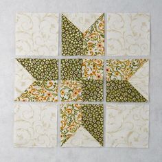 four quilt blocks with green and orange designs on the top one has an arrow in the middle