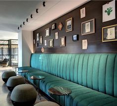 a restaurant with green velvet booths and pictures on the wall